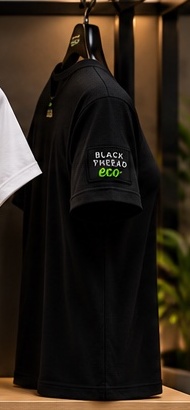 Illustrative black BLACK THREAD eco creator tee, side view on hanger